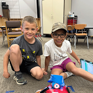 Two boys showing their craft project